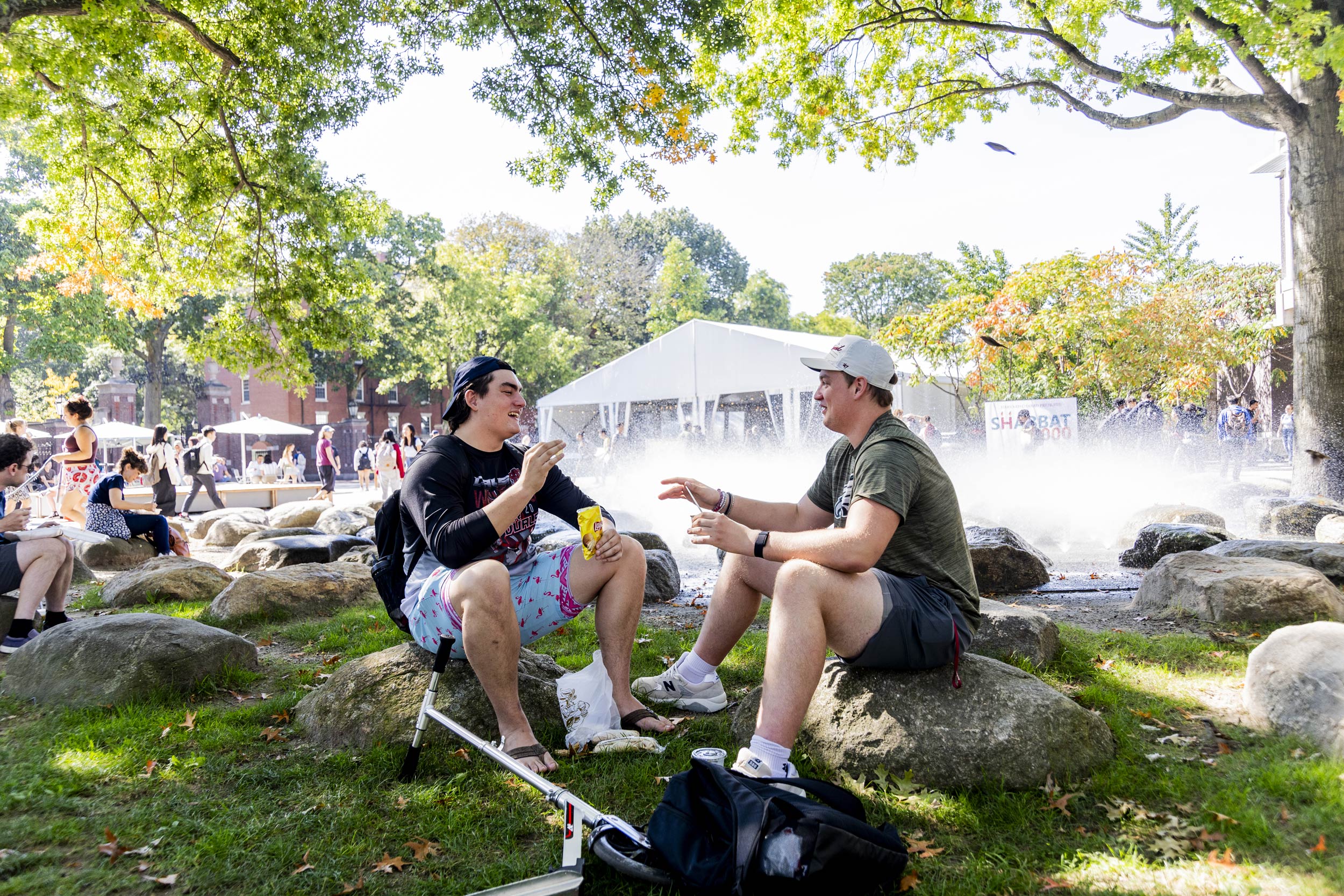 Two students share a conversation on the rocks outside of the Science Center.