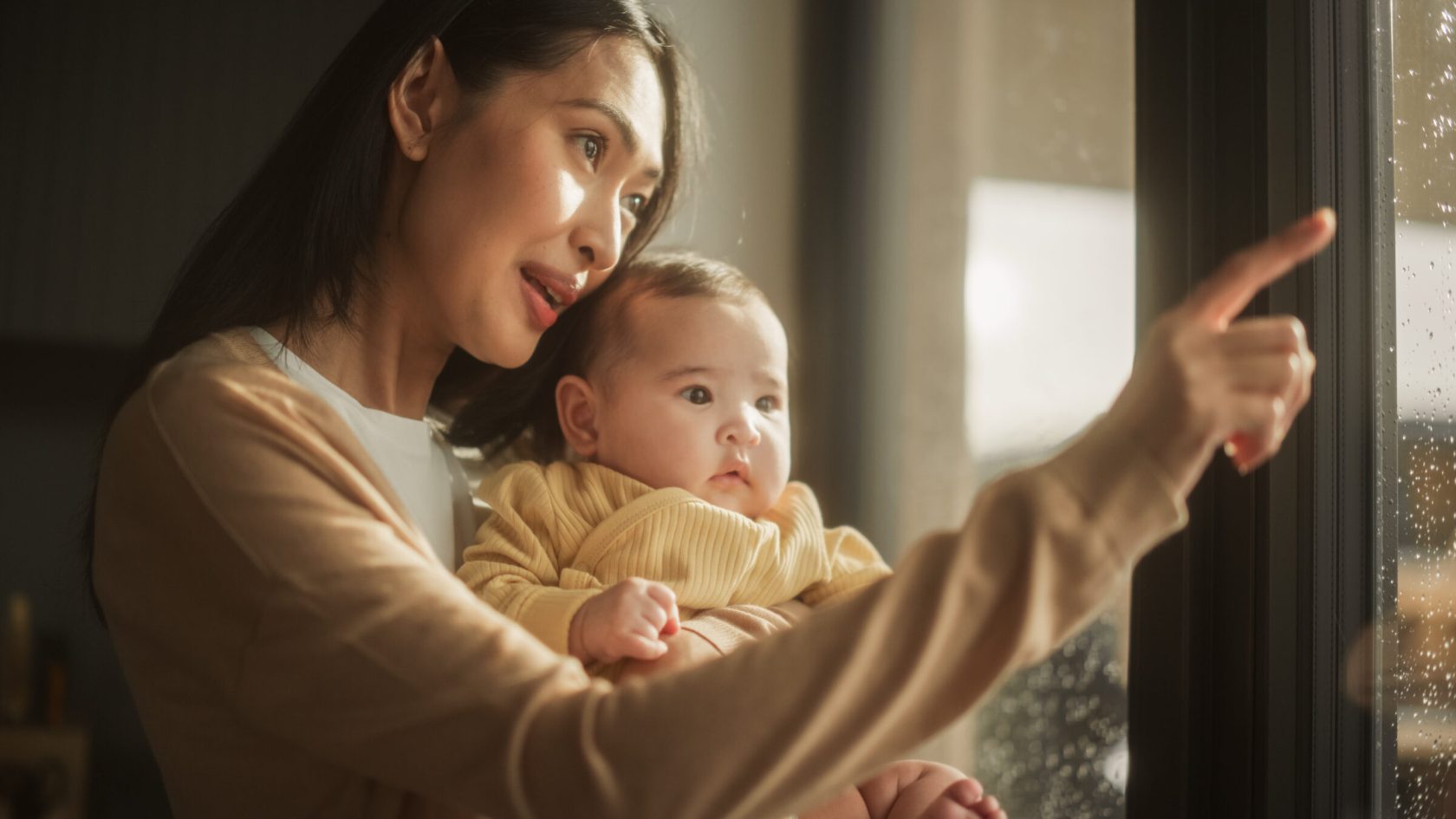 Mother pointing while talking to infant.