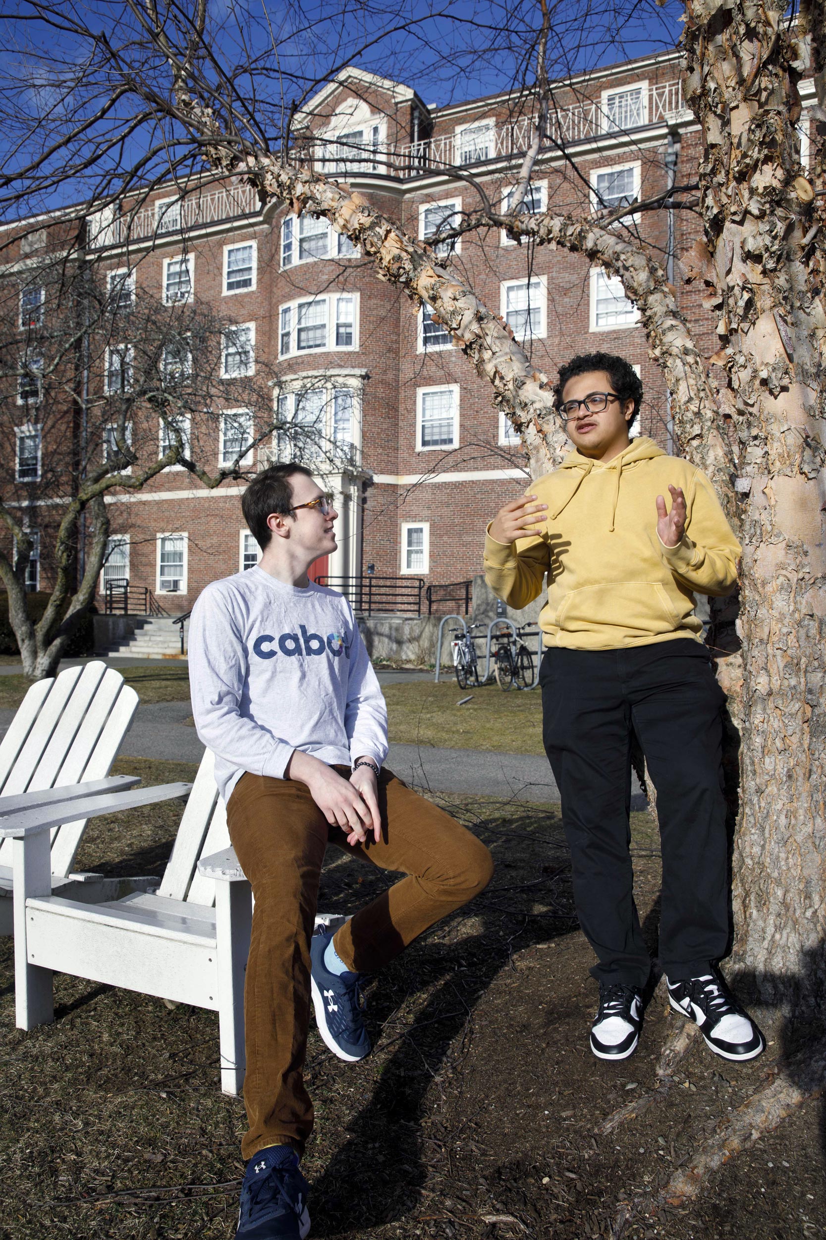 House Committee chairs, Gabe LeBlanc ’25 and Chris Hidalgo ’25 (yellow shirt) relax in the Radcliffe Quadrangle outside Cabot Hall