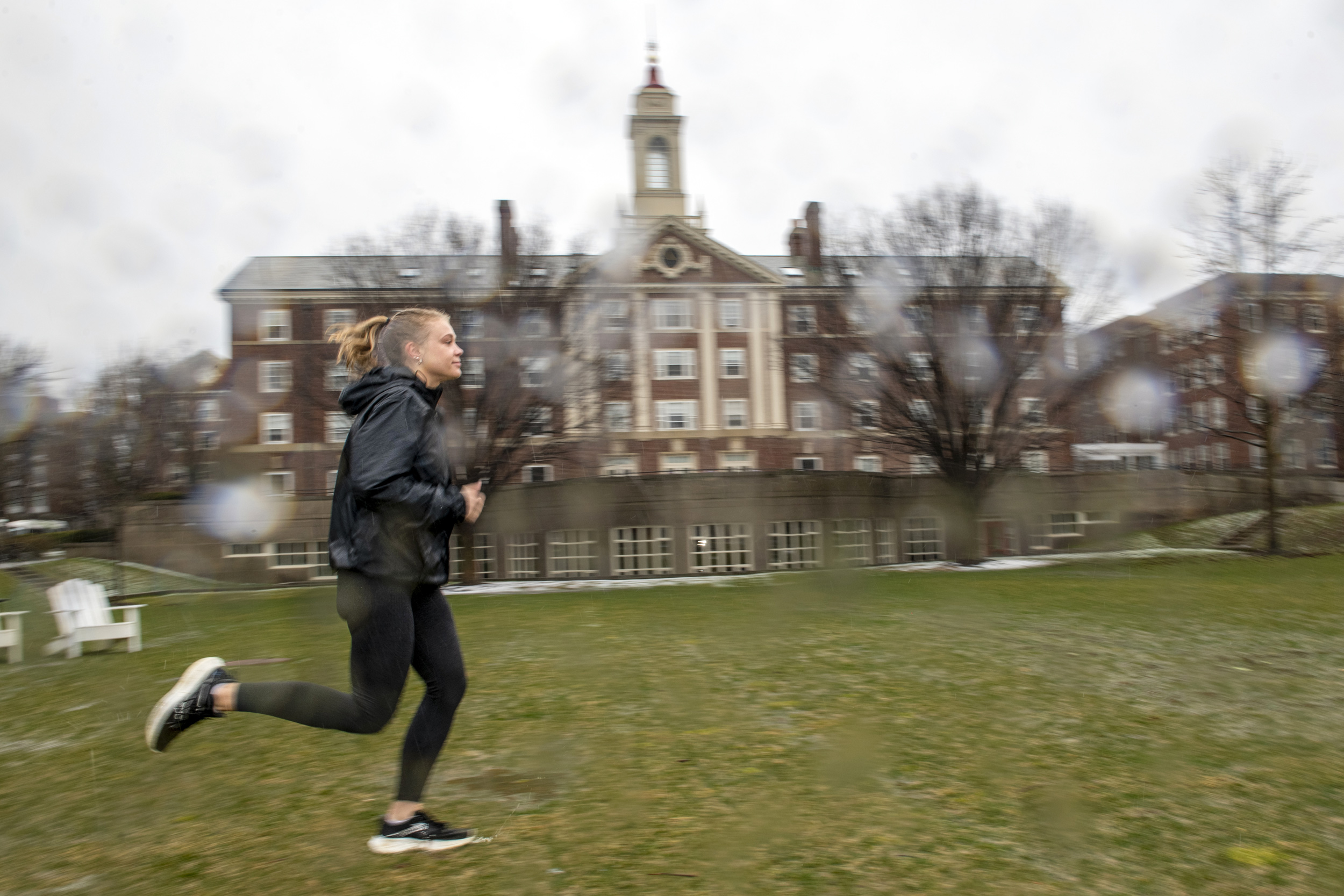 Morgan Sokol runs by Currier House in the rain.