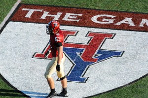 A football player standing on a logo of the Harvard/Yale Game