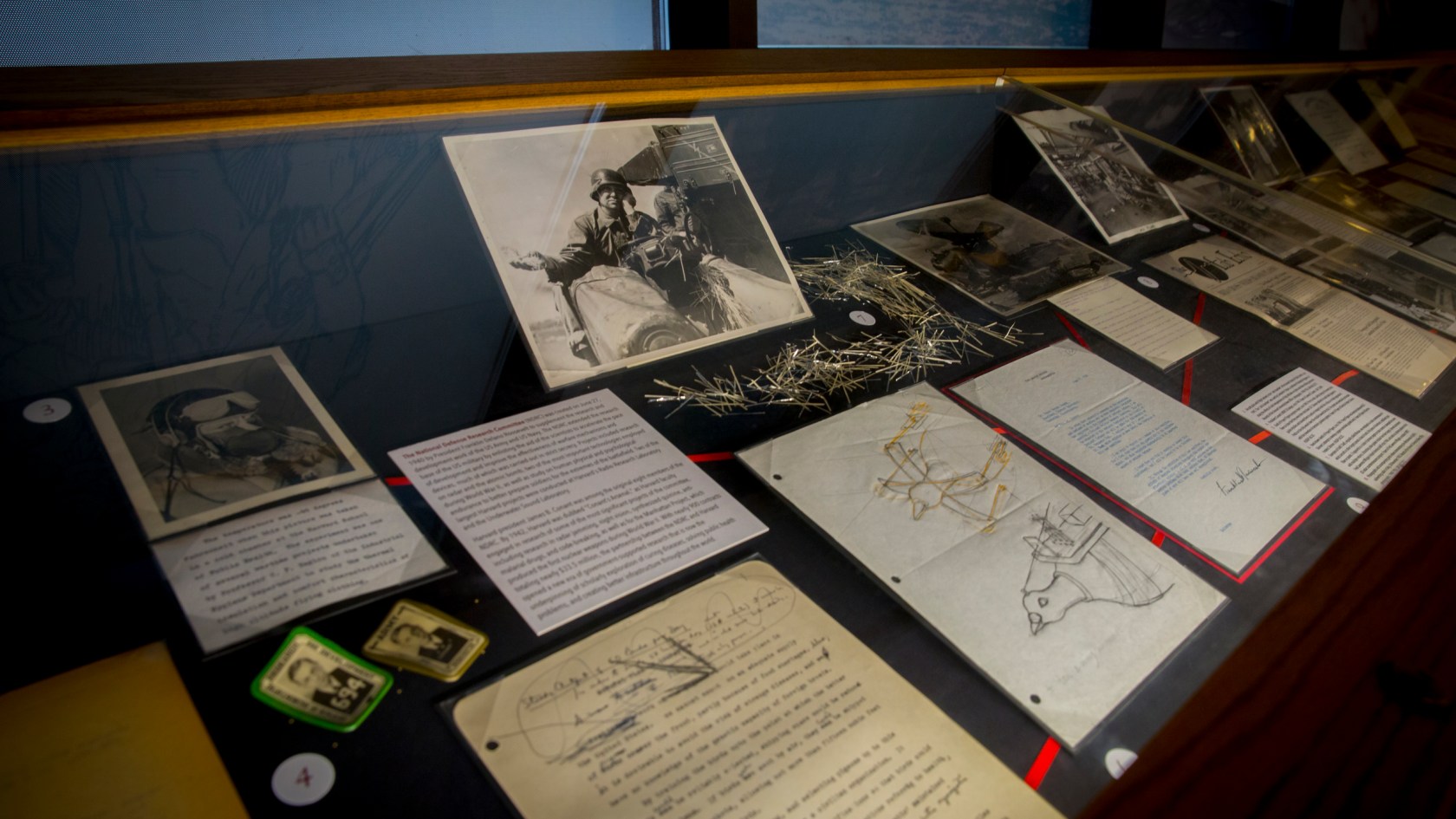 Historic papers and photos in an exhibit about Harvard and the military