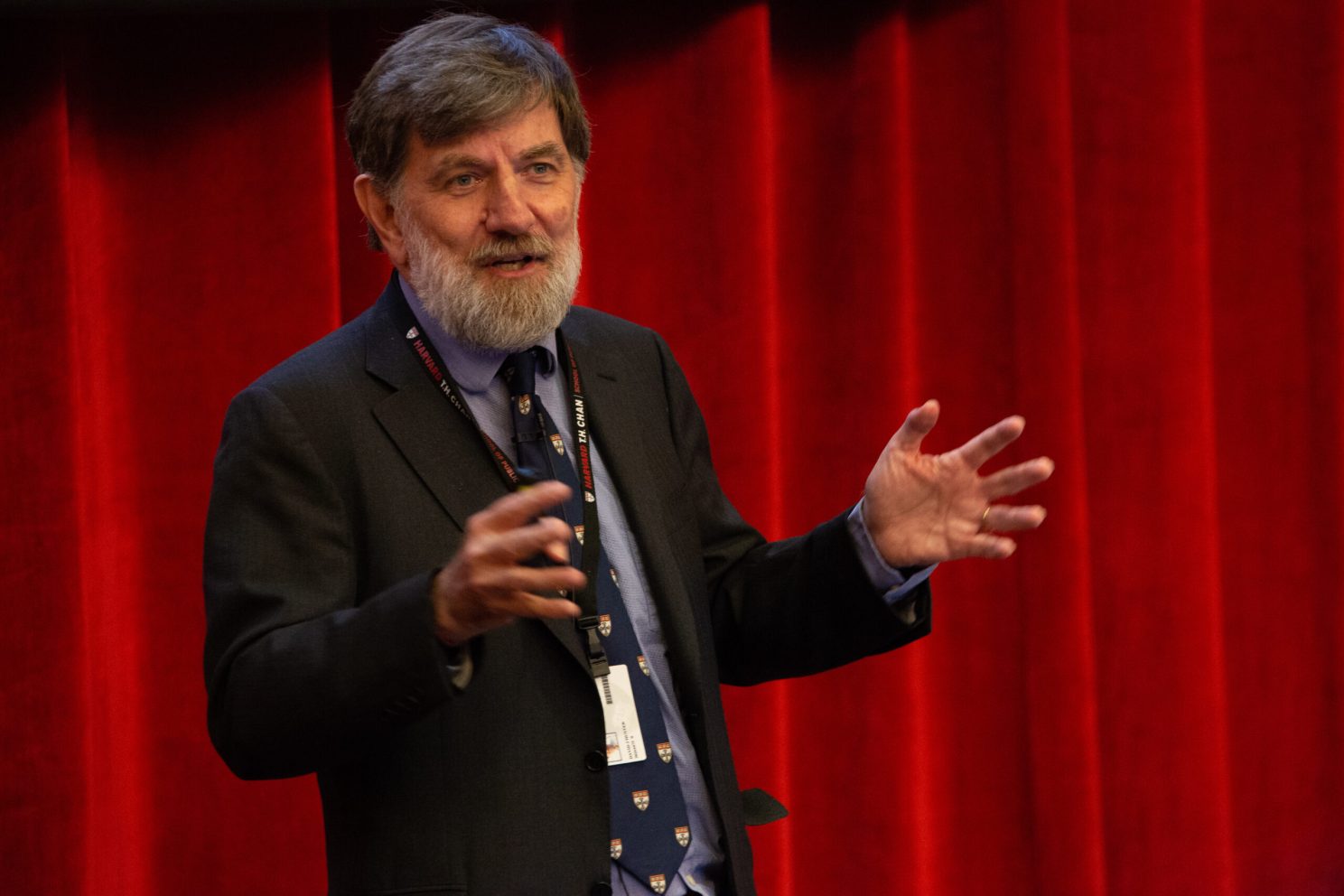 Man giving speech in front of curtain