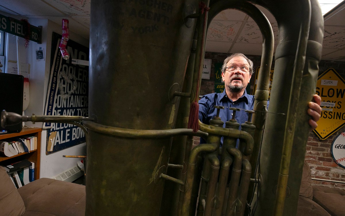 A man standing behind a giant tuba