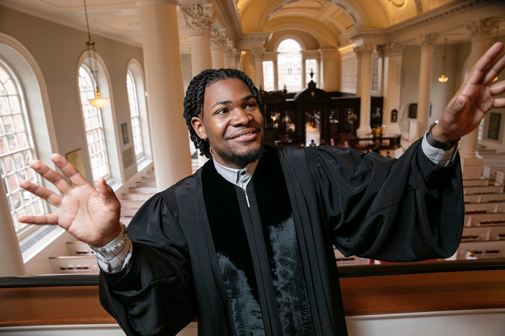 Aric Flemming in a priest's gown standing in church