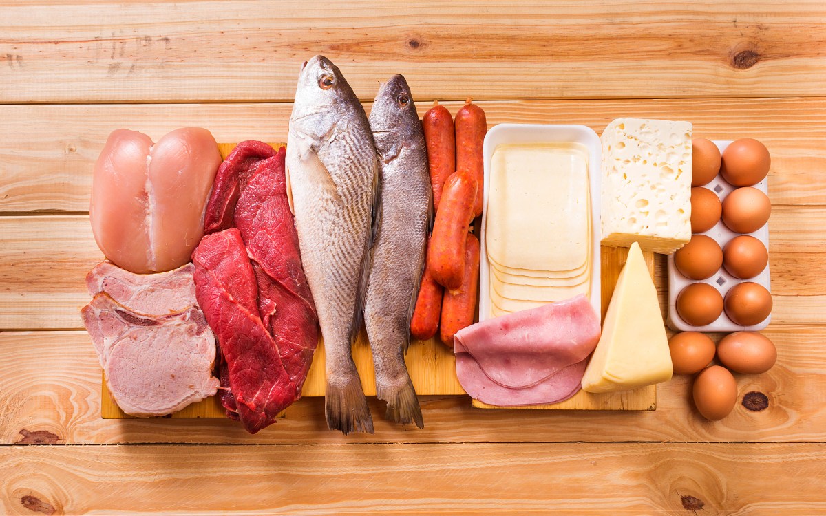 meats, fish, dairy, eggs, white meat on a wooden table as background