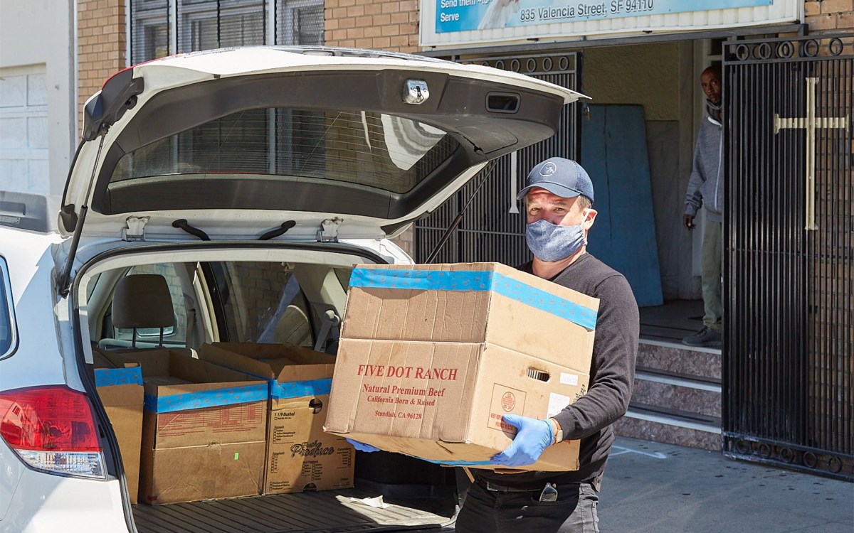 Loading boxes of food into a car.