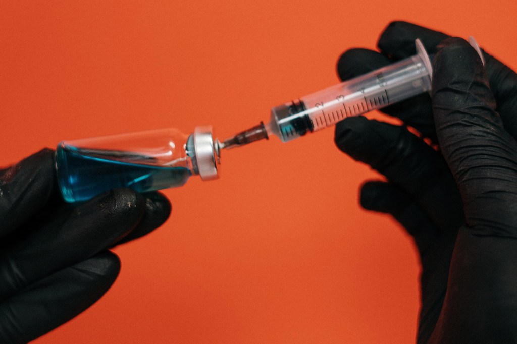 Vaccine being held in gloved hands.