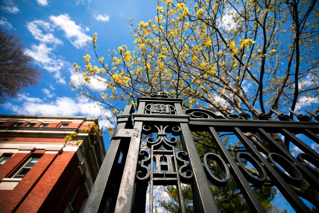 The gate along Quincy Street, featuring an "H" and veritas shield.