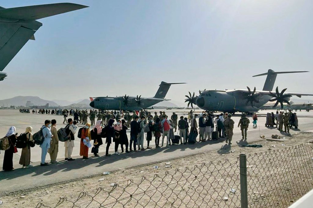 Afghan people wait at Kabul's airport.