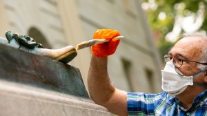 Robert Shure restoring John Harvard Statue.