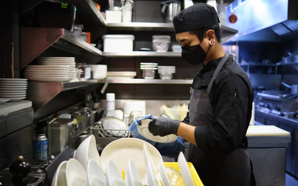 Worker washing dishes.