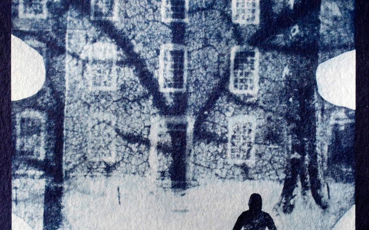 A cyanotype composites an oak leaf from Harvard Yard with a figure walking toward Massachusetts Hall.