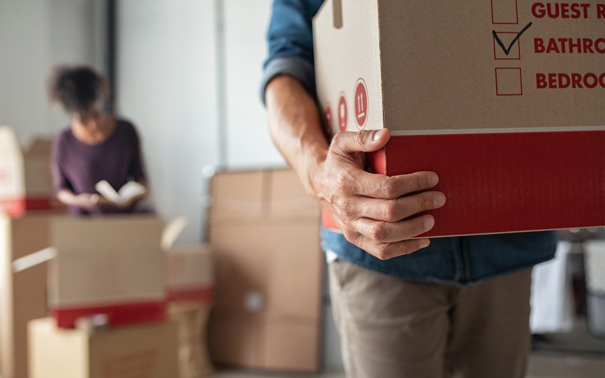 Young couple moving with boxes in hand.