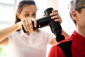 Man getting massage with massage gun.