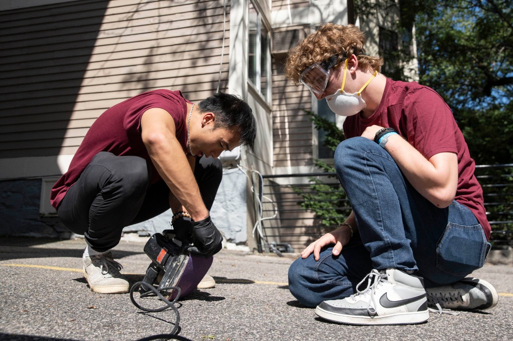 Xuanthe Nguyen ’25 and Luke Blanchette ’27 put sandpaper into the sander.