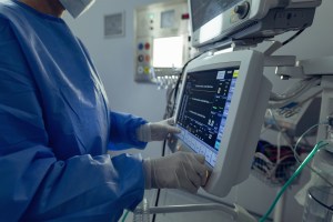 Doctor monitoring medical equipment in the ICU.