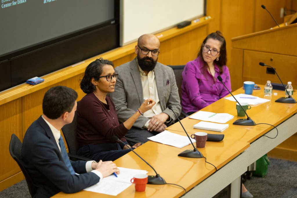 Eric Beerbohm (from left), Madura Rasaratnam, Mario Arulthas, and Kate Cronin-Furman sitting together in a lecture hall in front of microphones.