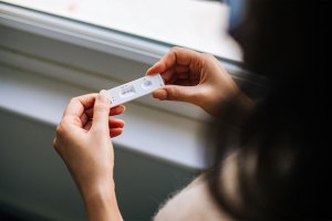 Woman Holding a Covid-19 Rapid Test At Home.