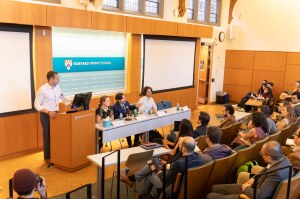 Charles M. Stang (from left), Christine Hauskeller, Mason Marks, and Roman Palitsky sitting at a table in a lecture hall at Harvard Divinity School.