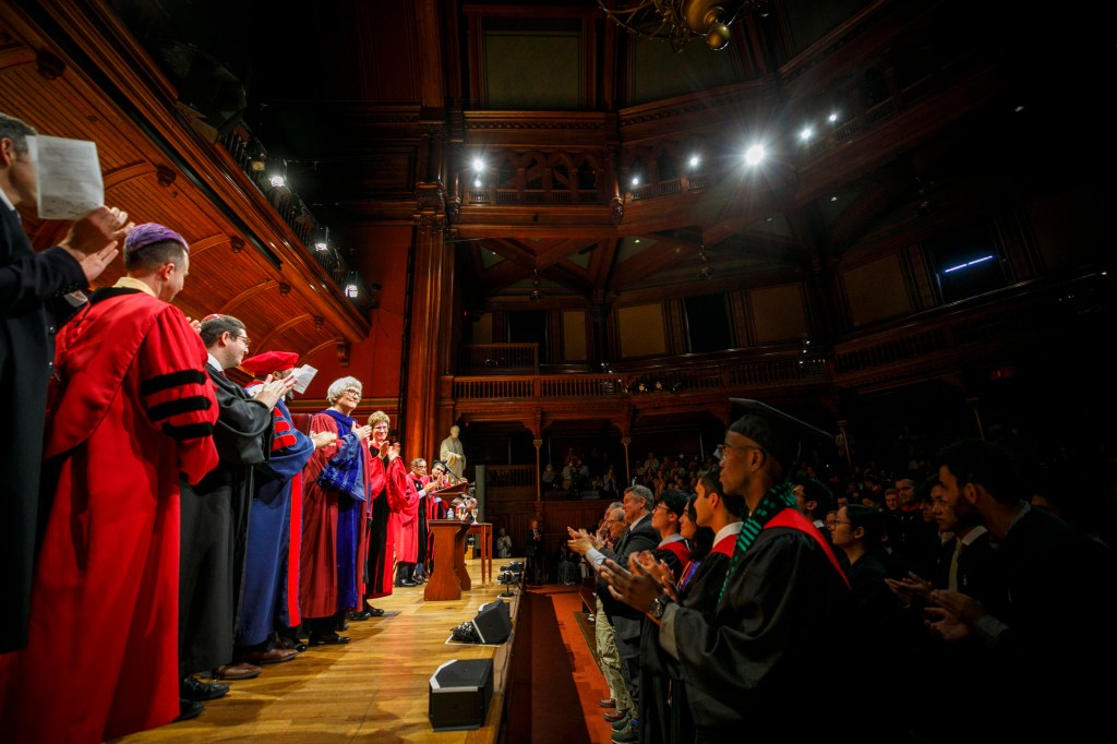 President Emerita Drew Faust (center) acknowledges the audience after receiving a standing ovation for her oration.