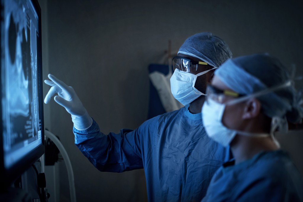 Two surgeons analyzing a patient’s medical scans.