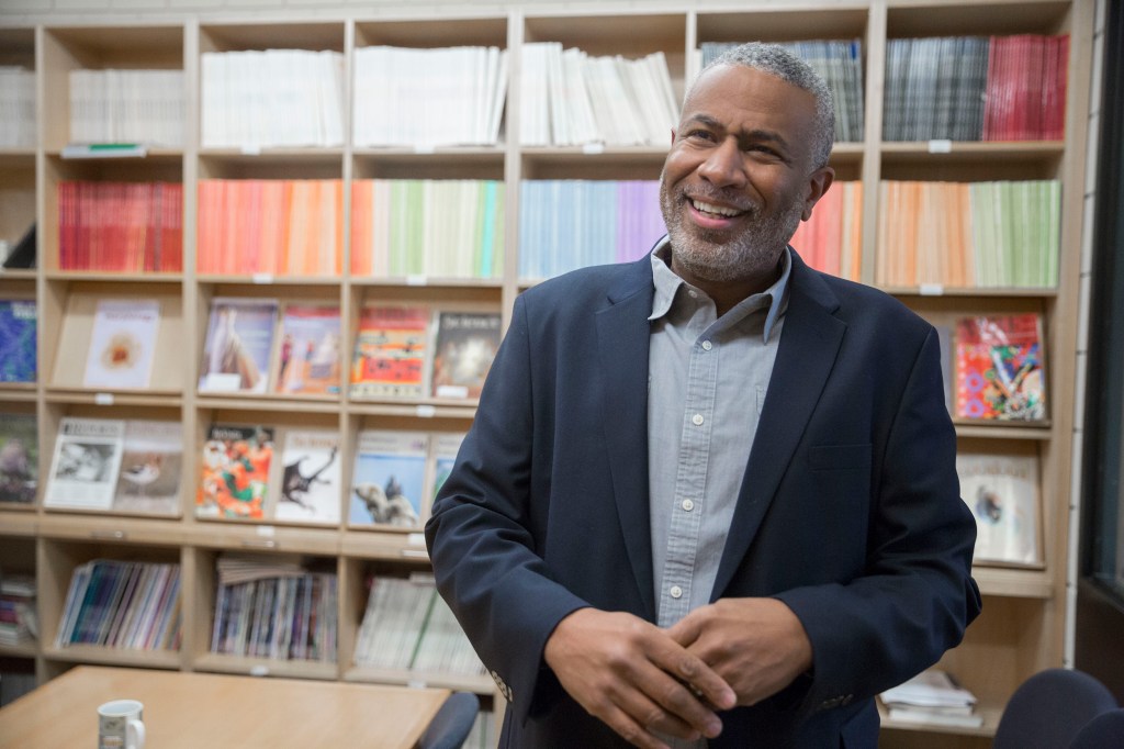 Scott Edwards standing against a bookcase.