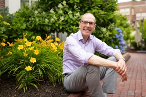 Martin Puchner sitting next to a flower bed.