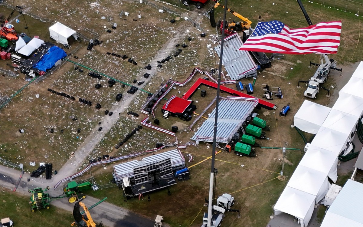 American flag flies in foreground of aerial view of Trump rally site days after attempted assassination.