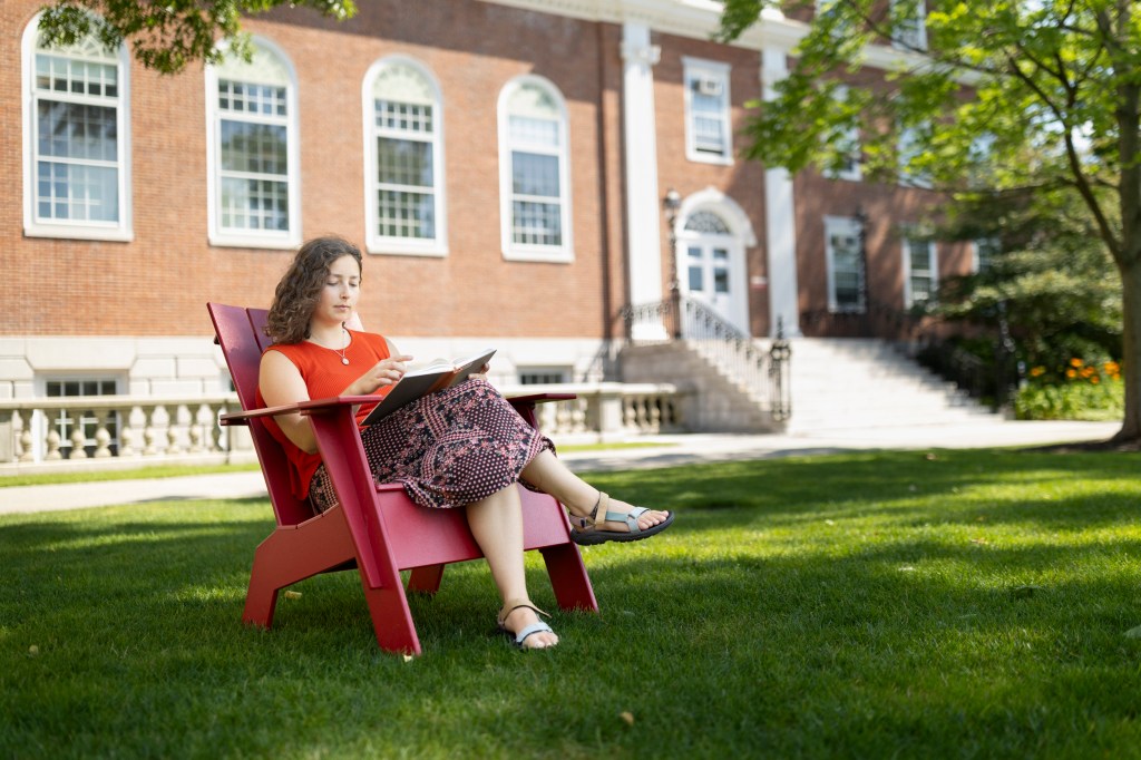 Emily Peck reading outside.