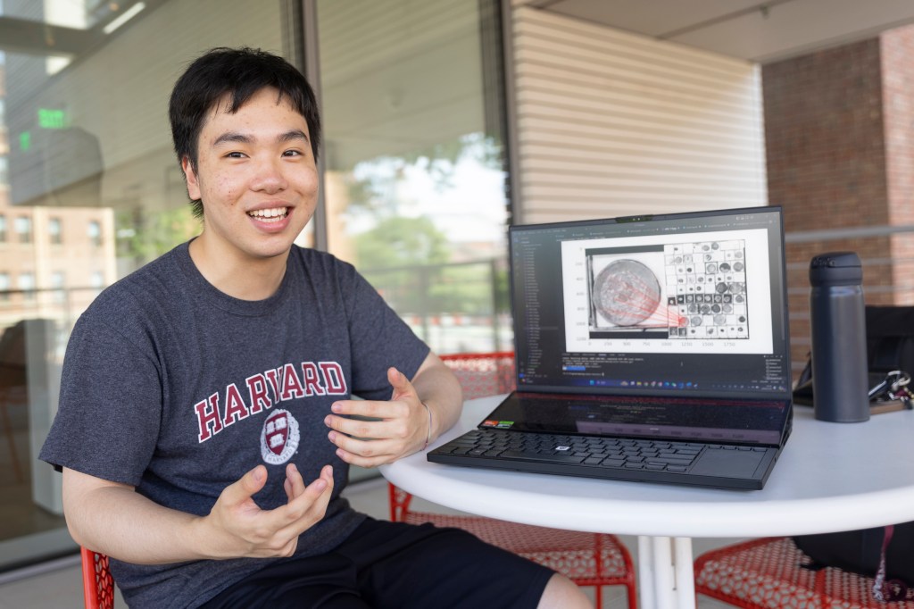 Puyuan “Alvin” Ye showing a coin on his laptop. 