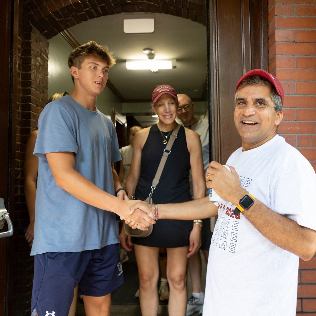 Andrew Van Stone ’28 (from left) and their mother, Sarah Van Stone, meet Rakesh Khurana, Danoff Dean of Harvard College.