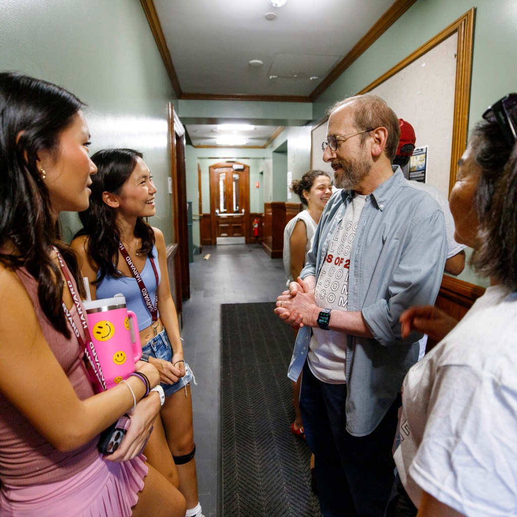 Twins Rachele (left) and Michelle Chung speak with Harvard President Alan Garber and his wife, Anne Yahand.