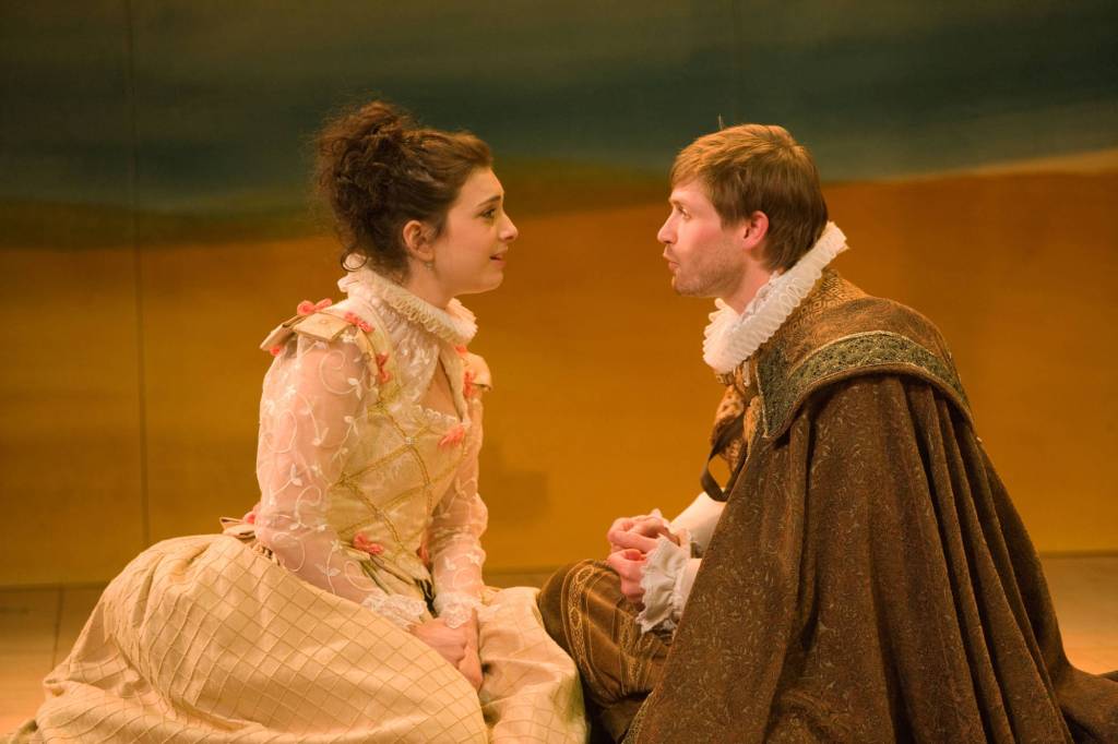 Man and woman sitting on stage.