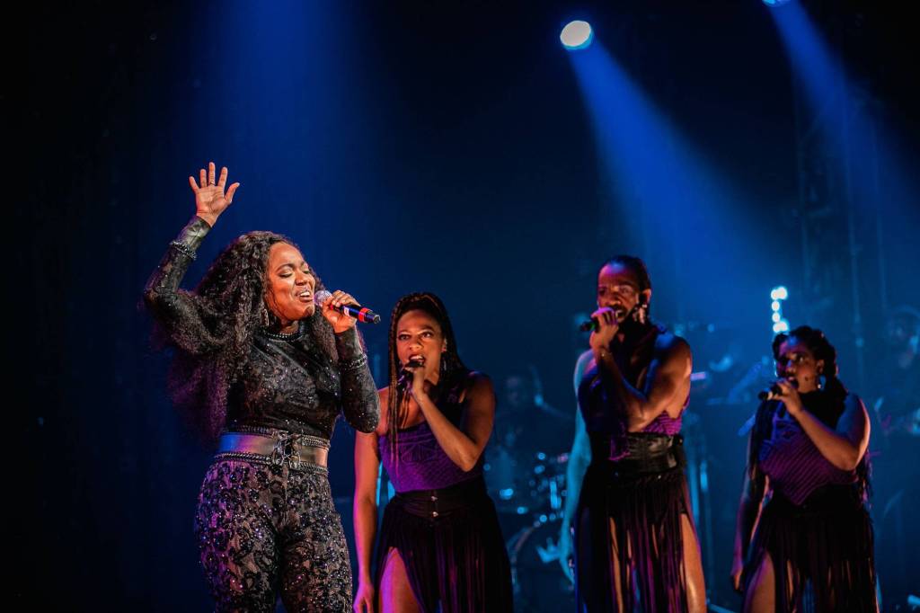 Woman singing in spotlight. 