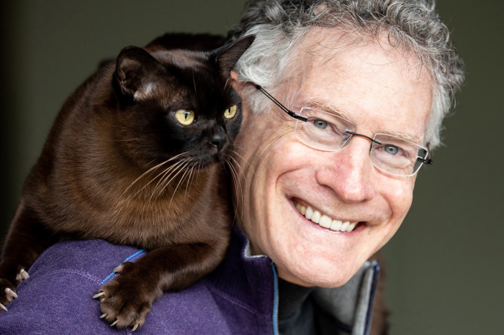 Jonathan Losos with a cat on his shoulder.