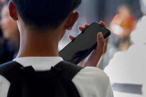 Student uses cellphone in school hallway.