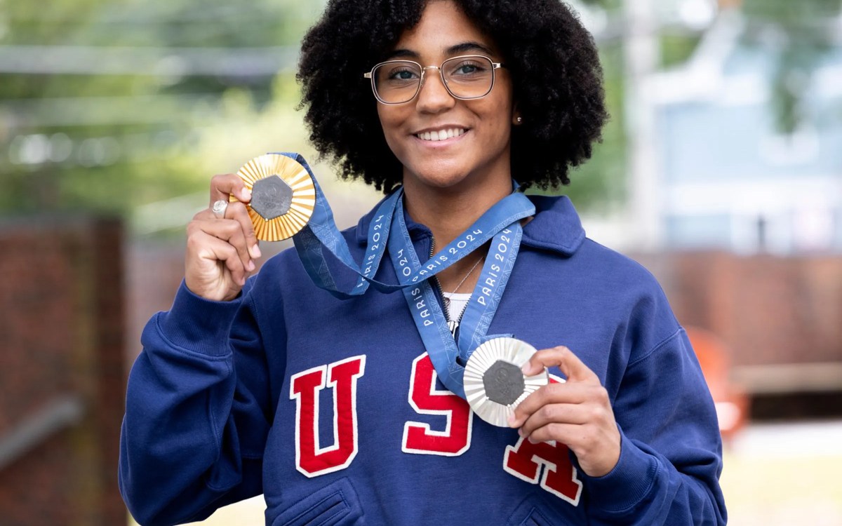 Lauren Scruggs Portrait holding up a silver and gold medal.