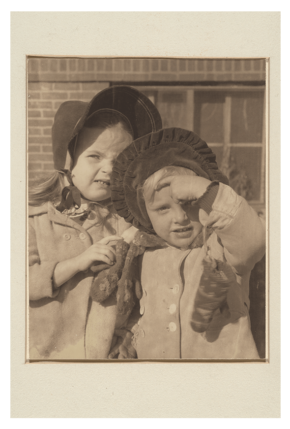 Two young girls embrace as they pose for a photo. 