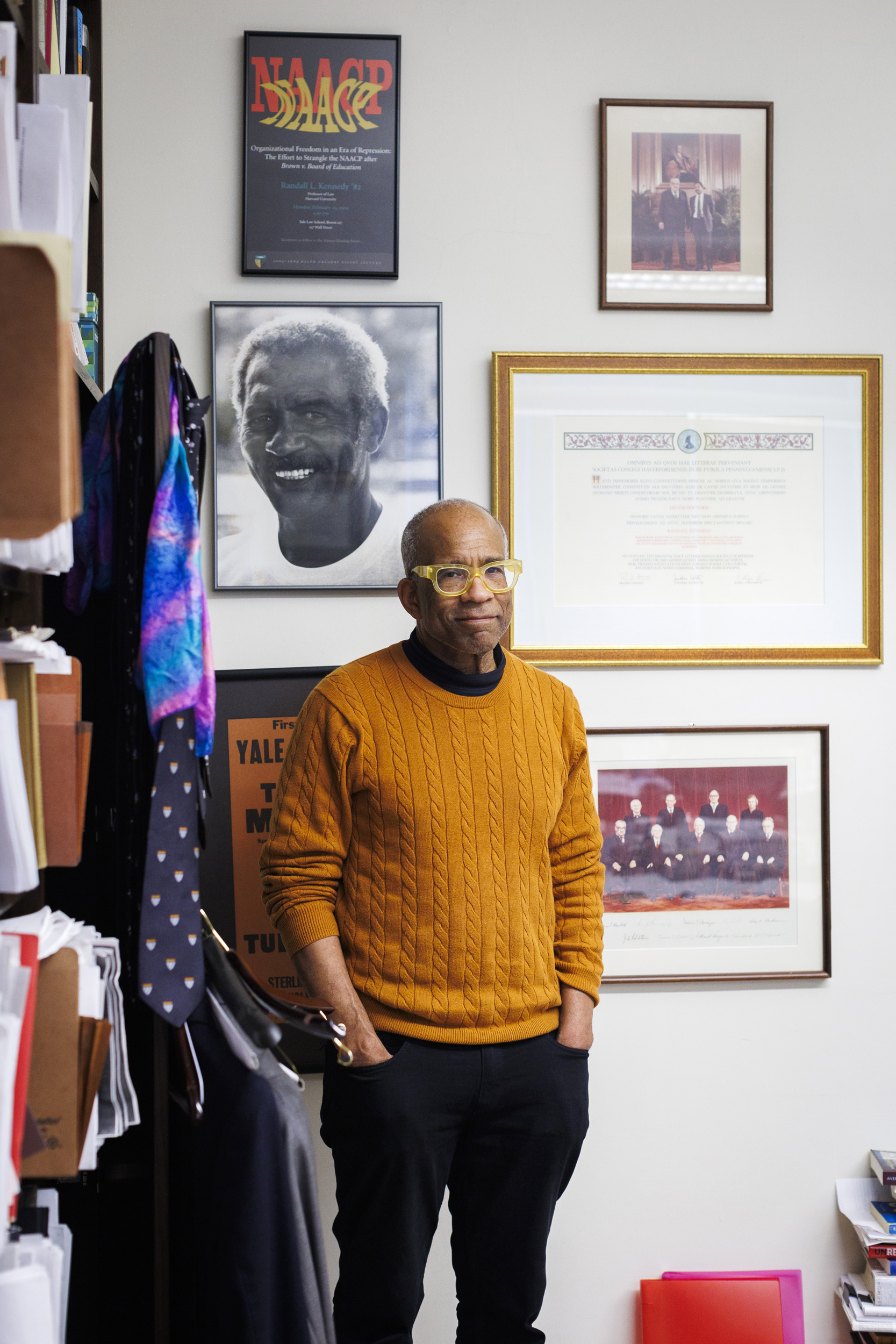 Randall Kennedy in his Harvard Law School office alongside a portrait of his father Henry.