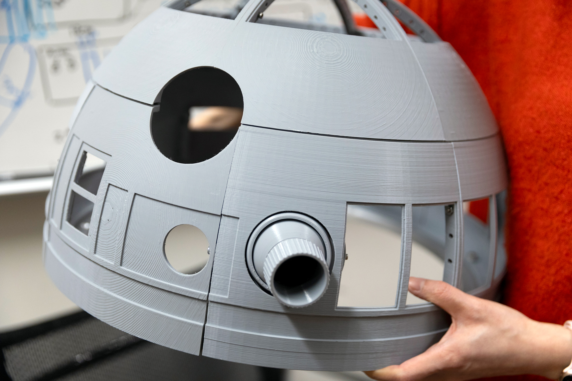 Yuwei Li, Neurotechnology Engineer at the Center for Brain Science and drawer, holds a 3d printed model she made of R2-D2’s head from Star Wars.