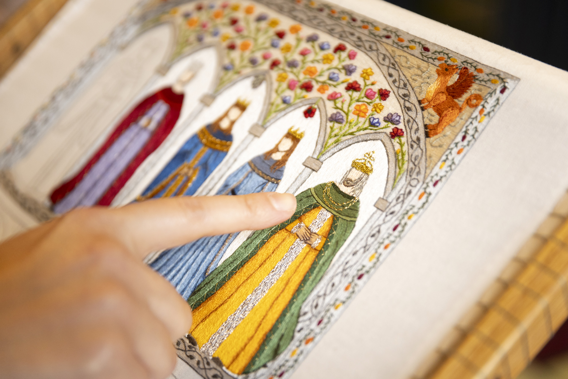 Veronica Bagnole, Digital Project Manager for the Harvard Graduate School of Design and embroiderer, points to the gold necklace she improvised from the original pattern she had created for this embroidery piece.