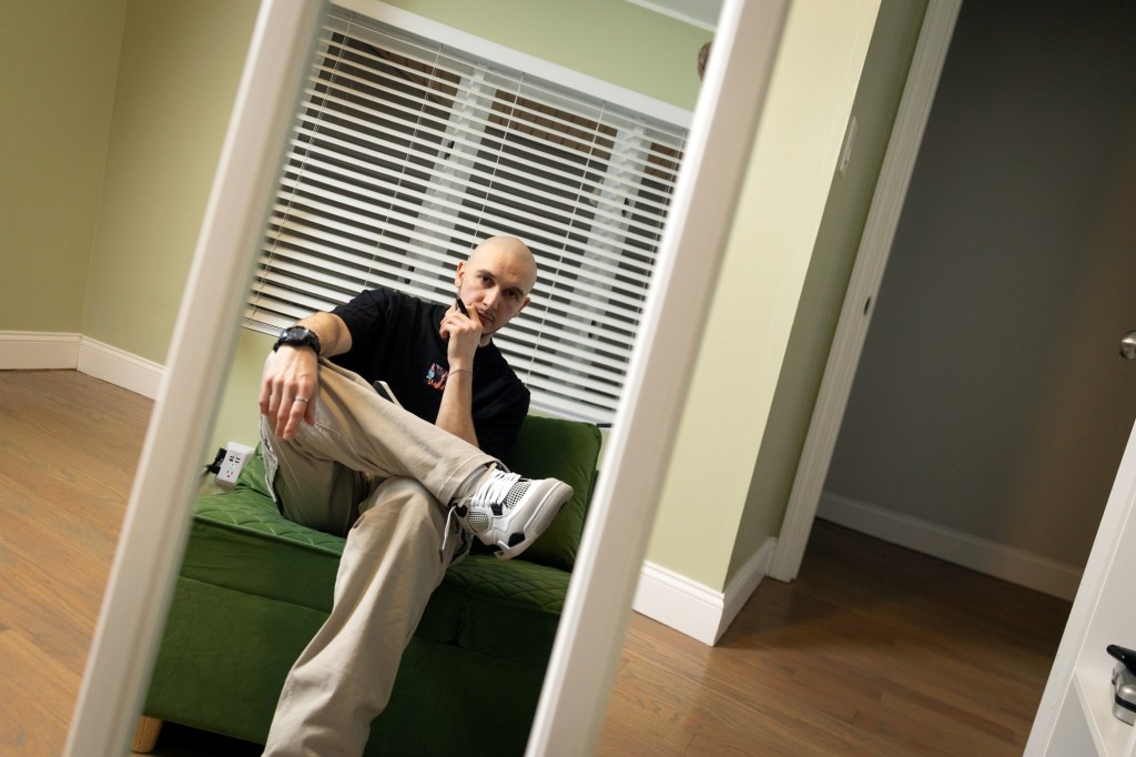 Stanislav Karachev, Energy Performance Engineer for Harvard Medical School, dancer, and poet, posing for a photo in his apartment in Roxbury.