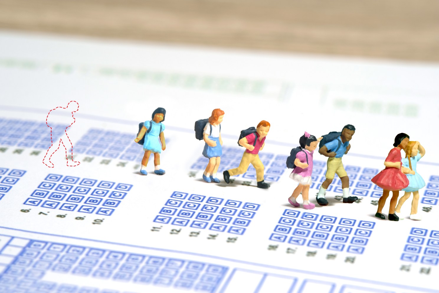 Illustration of a child left behind a group of schoolchildren on math and reading exams.