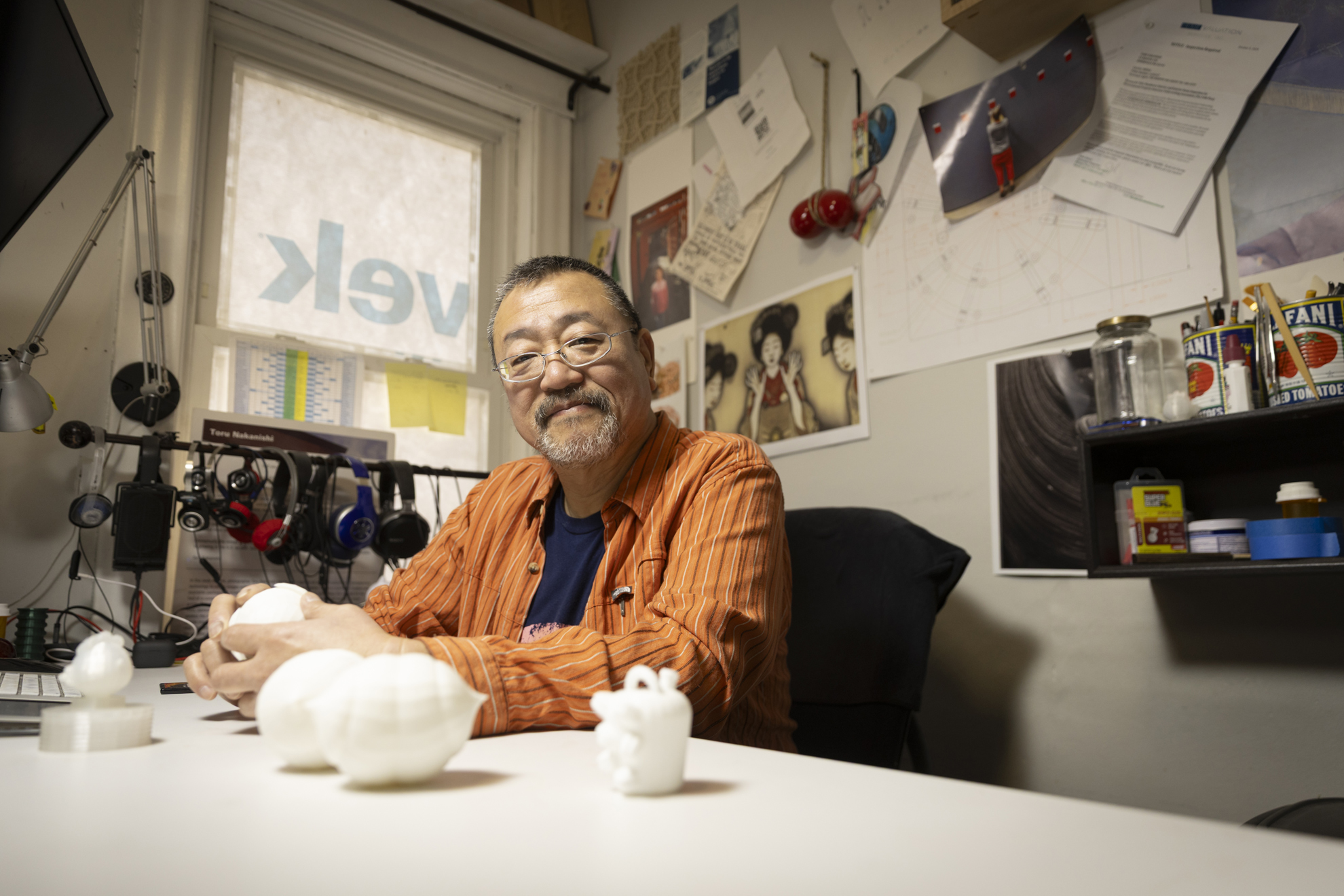 Toru Nakanishi, Production Specialist at the Harvard Art Museums, photographer, and sculptor at his desk with several of his sculpture pieces in his apartment in Somerville, MA.