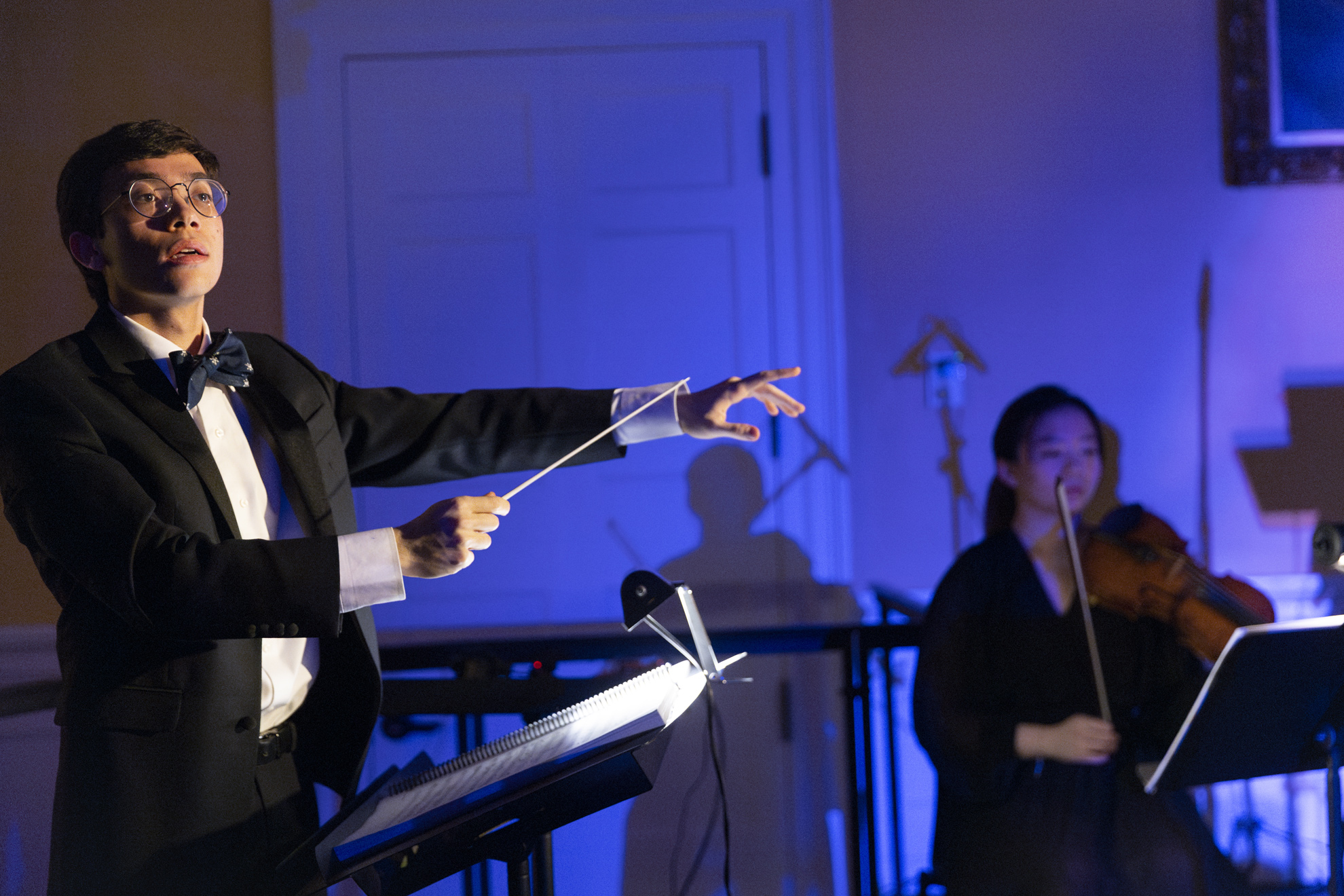 Benjamin T. Rossen ’23, Music Director and Conductor, conducting the musicians.