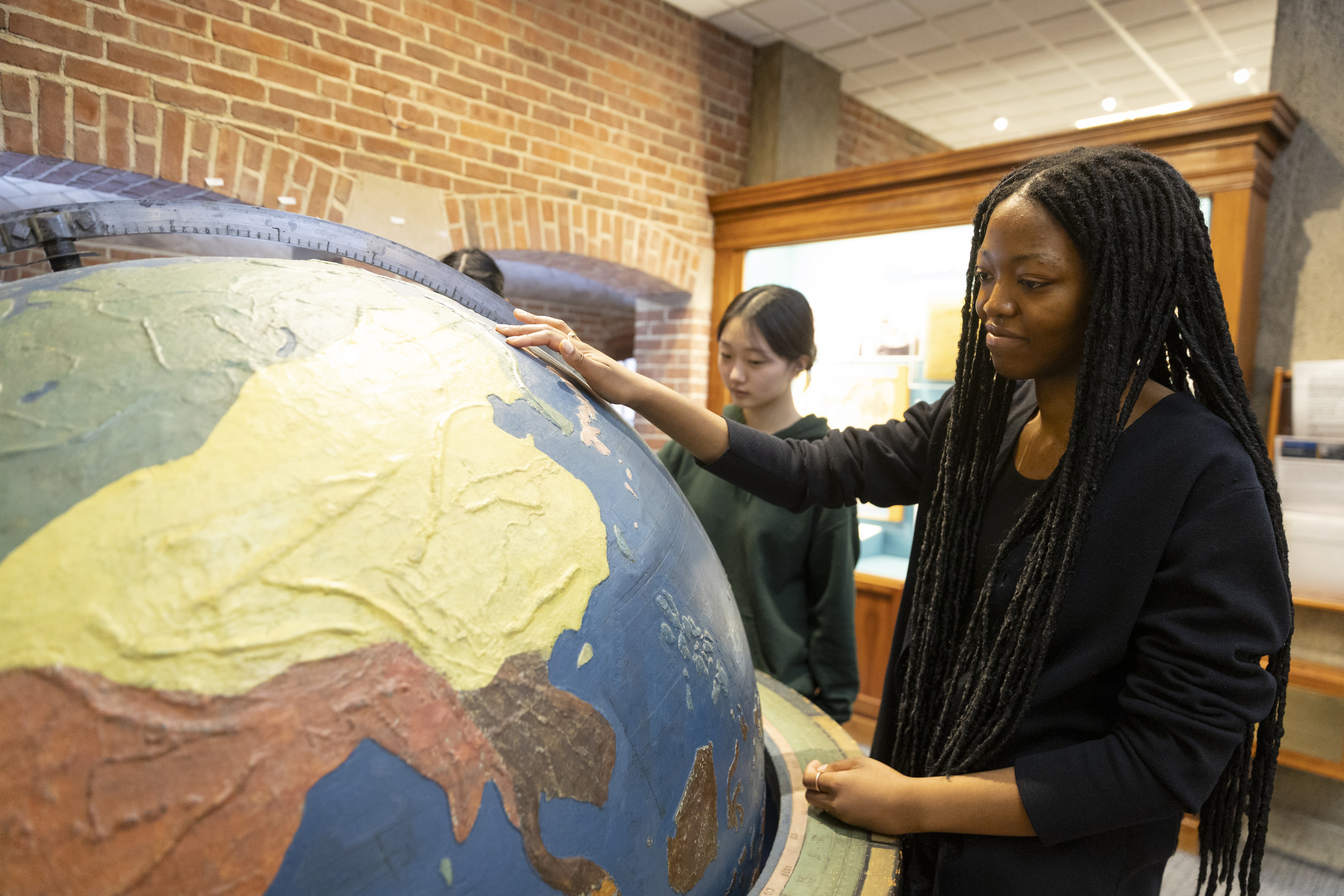 Amy Ojeaburu '25 examines a giant tactile globe.