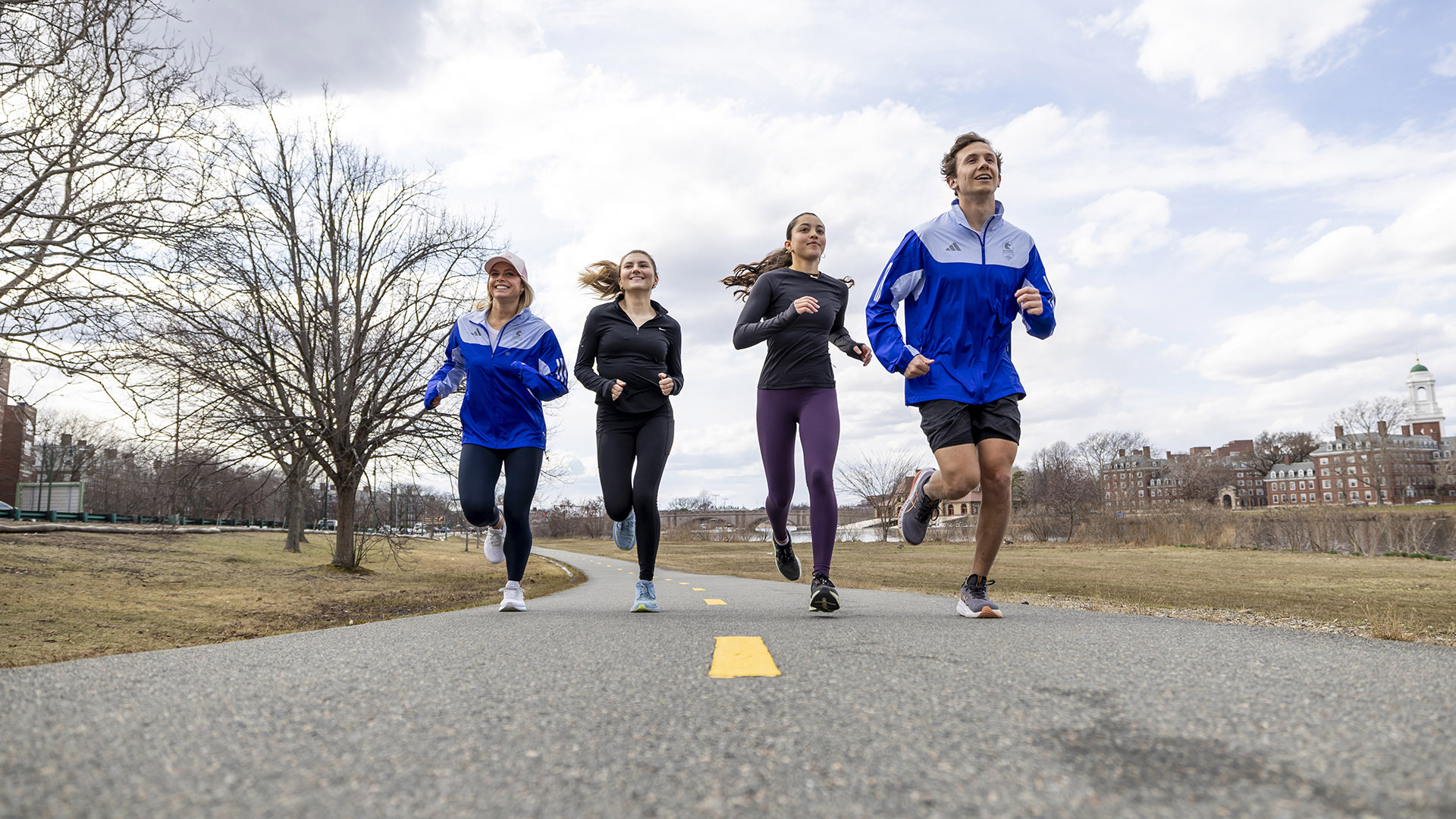 Bridget Kondrat, Maggie Chiappetta-Uberti, Brooke Stanford, and Andrew Athanasian run along the Charles River.