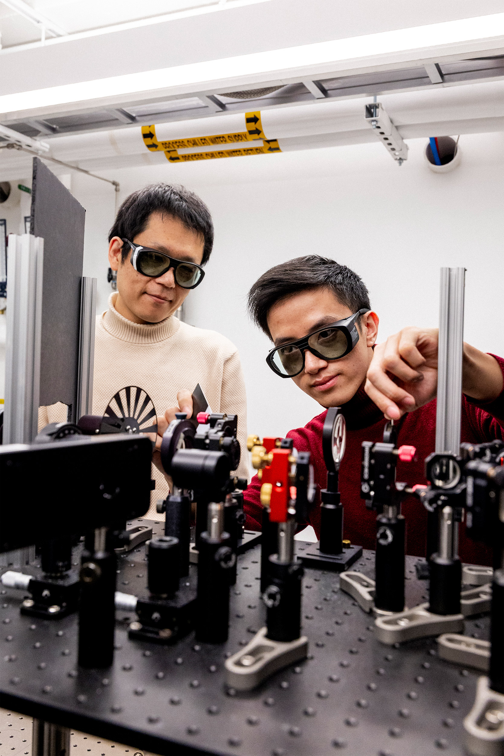 Jian-Xiang Qiu (left) and Professor Suyang Xu adjust the lasers inside the Axion Quasiparticle 