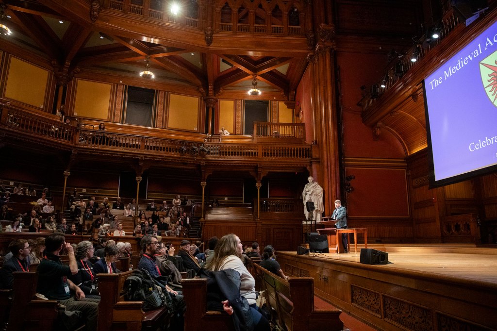 Sean Gilsdorf speaking in front of Sanders Theatre audience.
